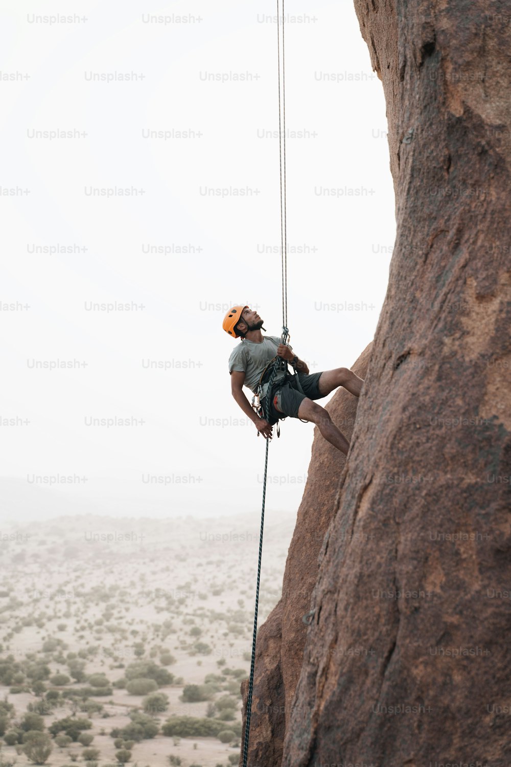 a man climbing up the side of a mountain