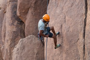 a man climbing up the side of a mountain