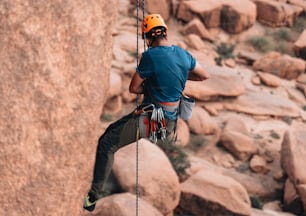 a man on a rock climbing up the side of a mountain