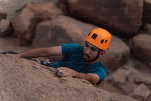 Un uomo con un elmetto che si arrampica su una roccia