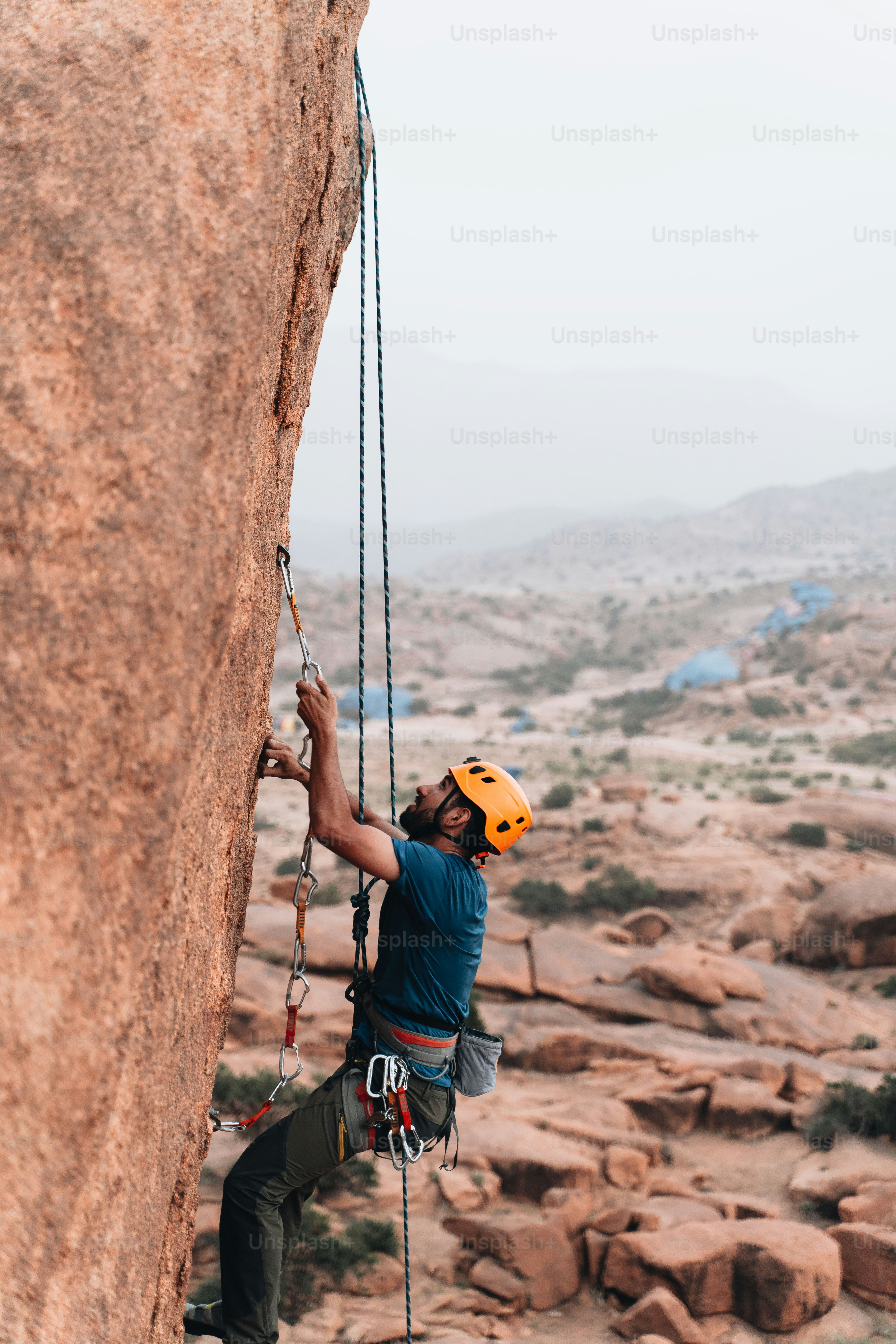 Un homme grimpant sur le flanc d’une montagne