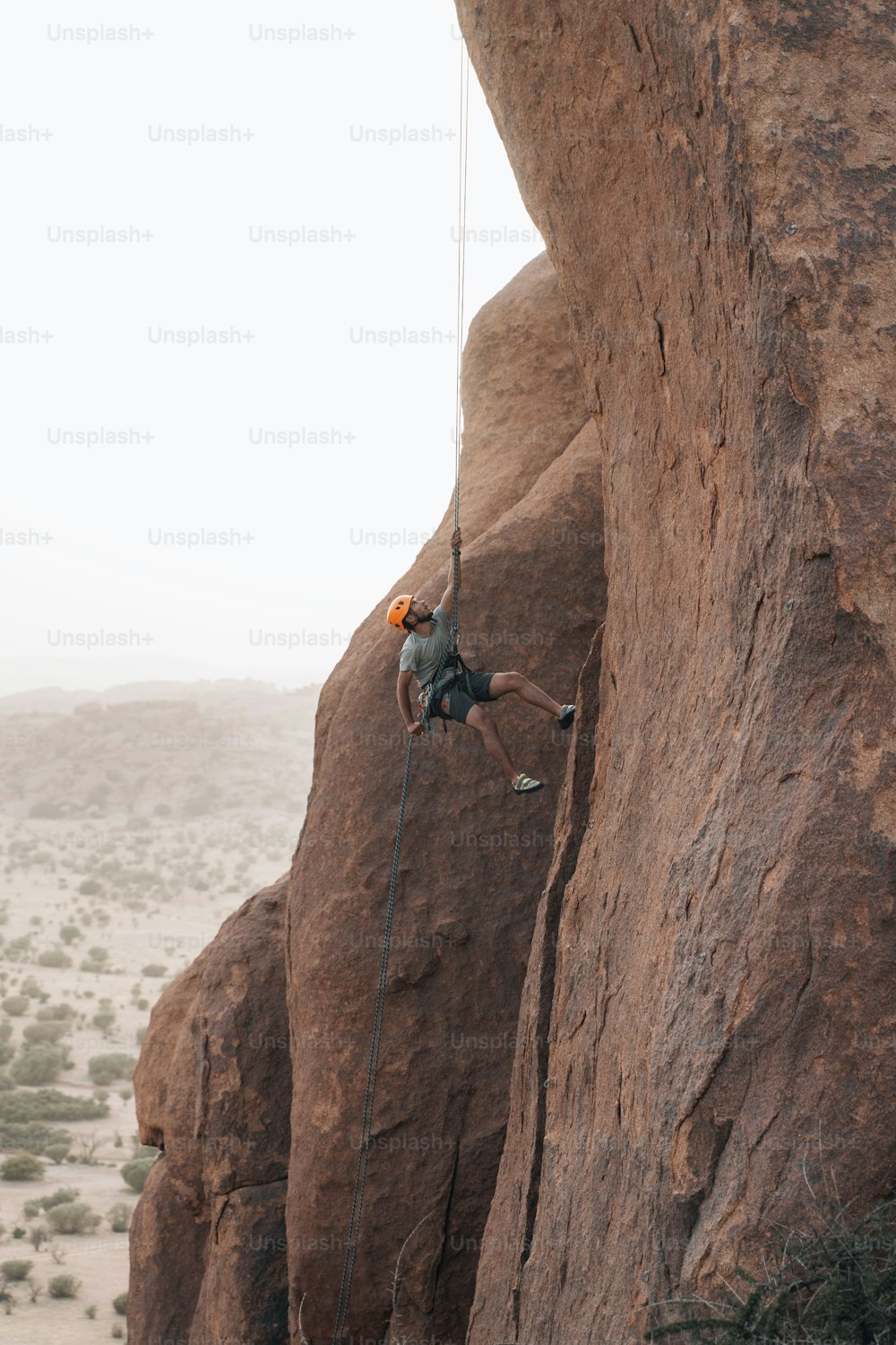 a man climbing up the side of a large rock