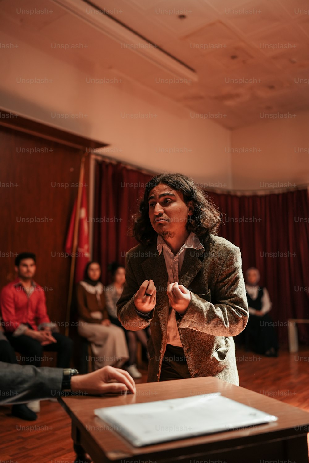 a man standing in front of a wooden table