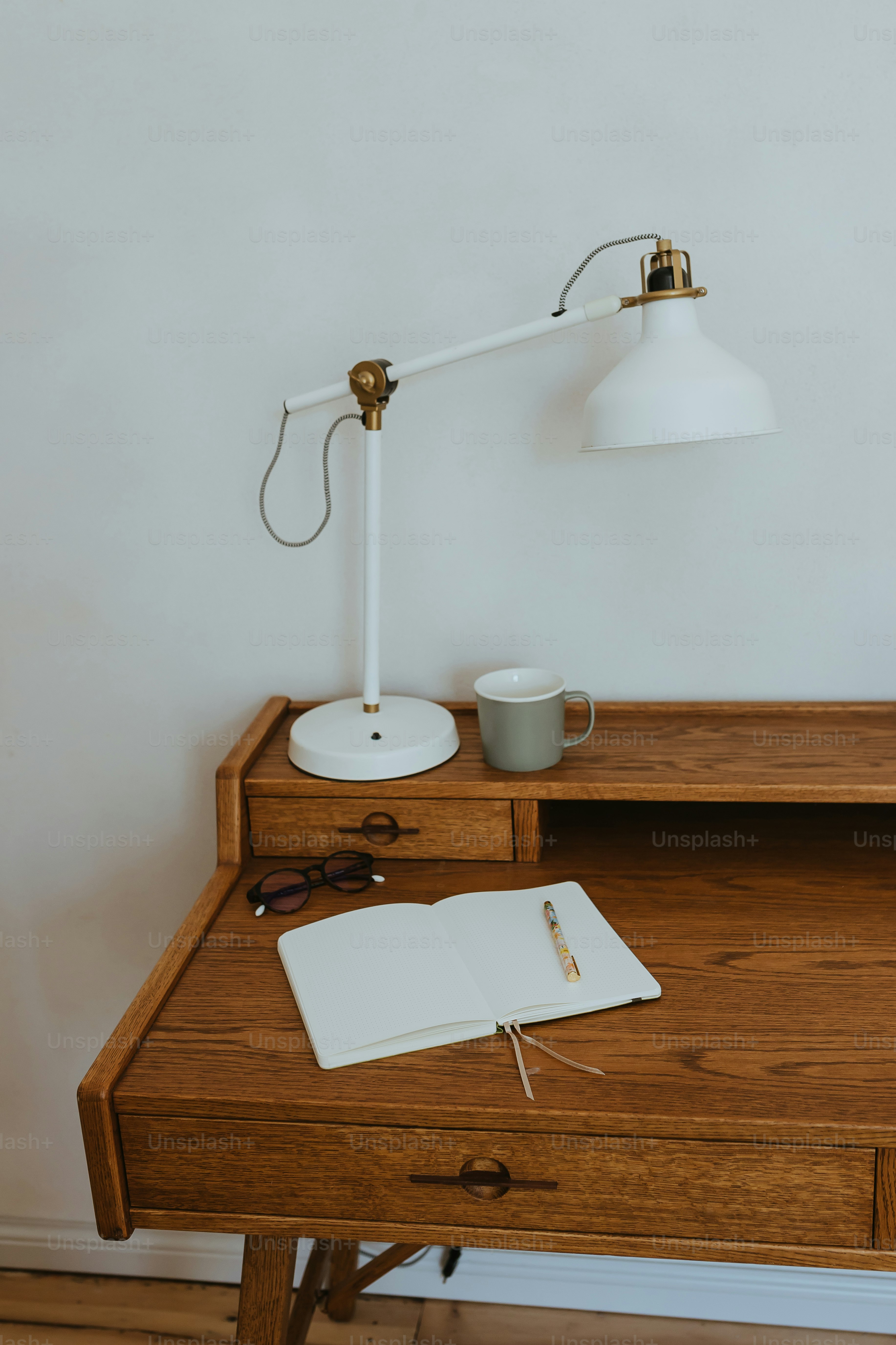 a desk with a lamp and a book on it