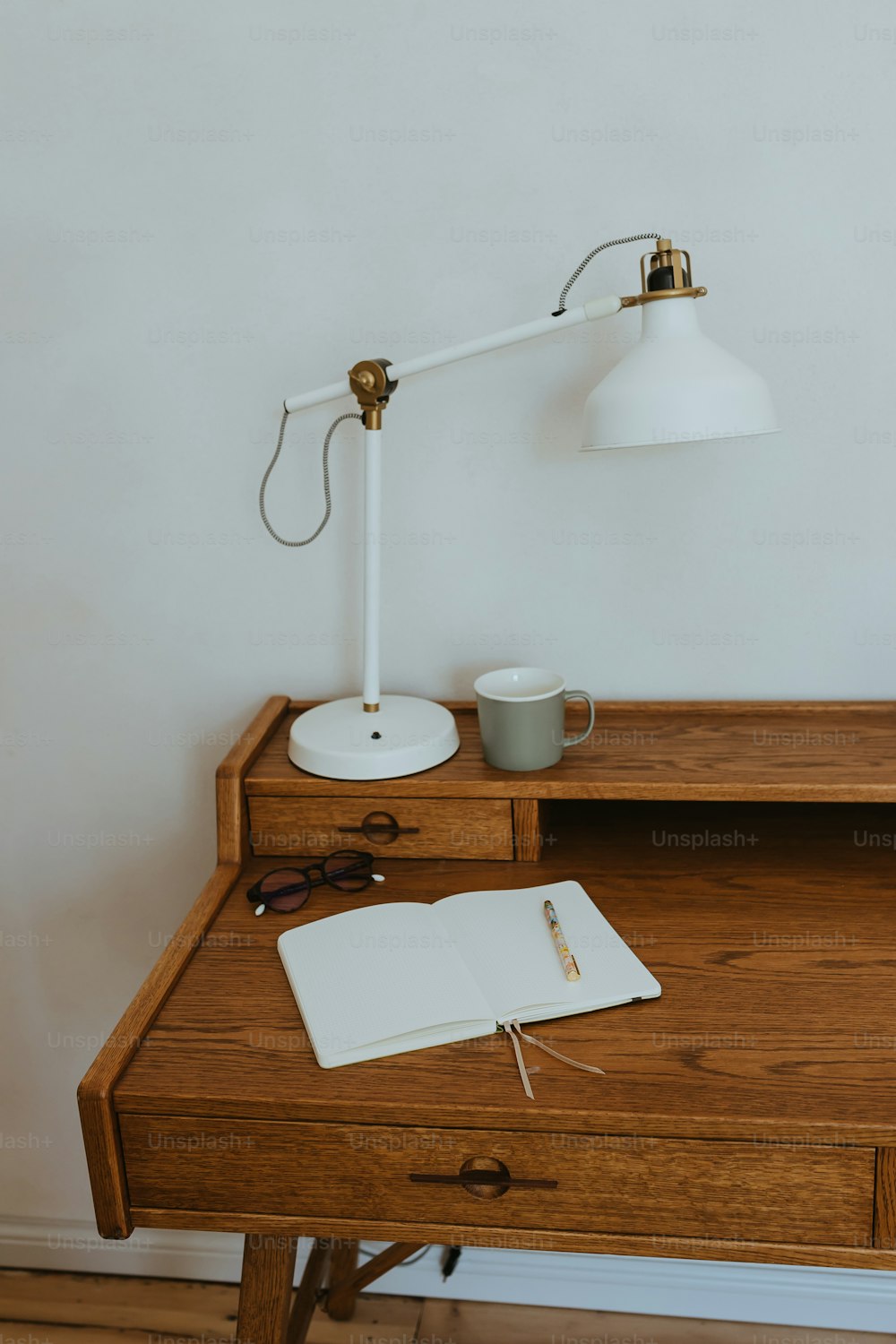 a desk with a lamp and a book on it