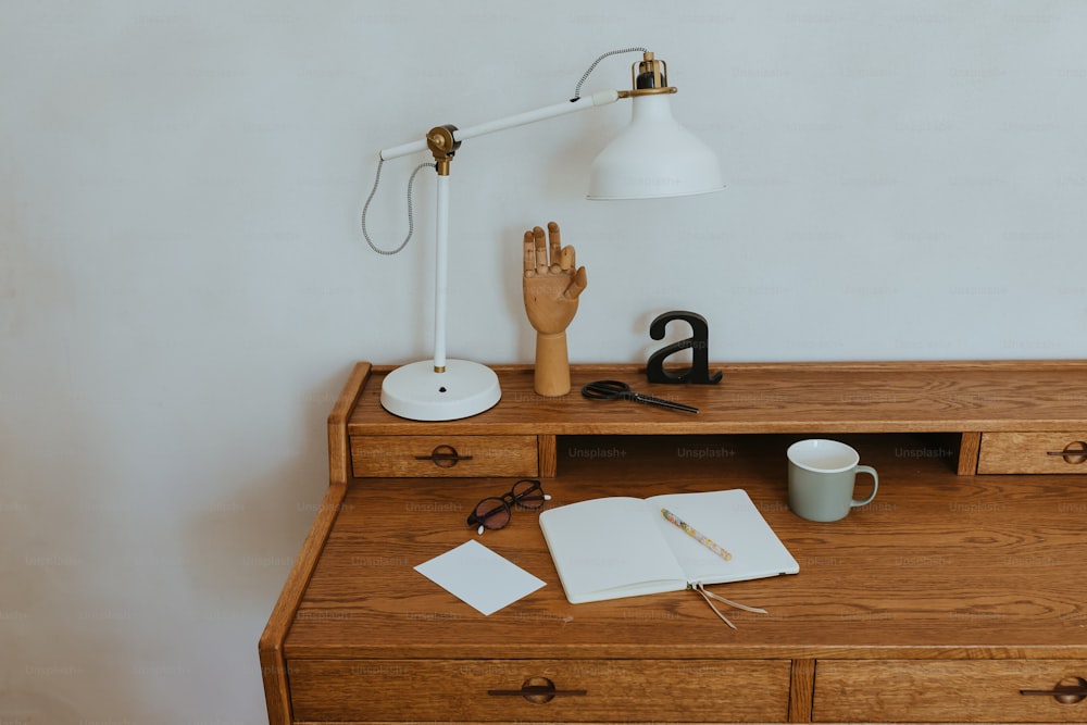 uma mesa de madeira coberta com uma lâmpada e um livro