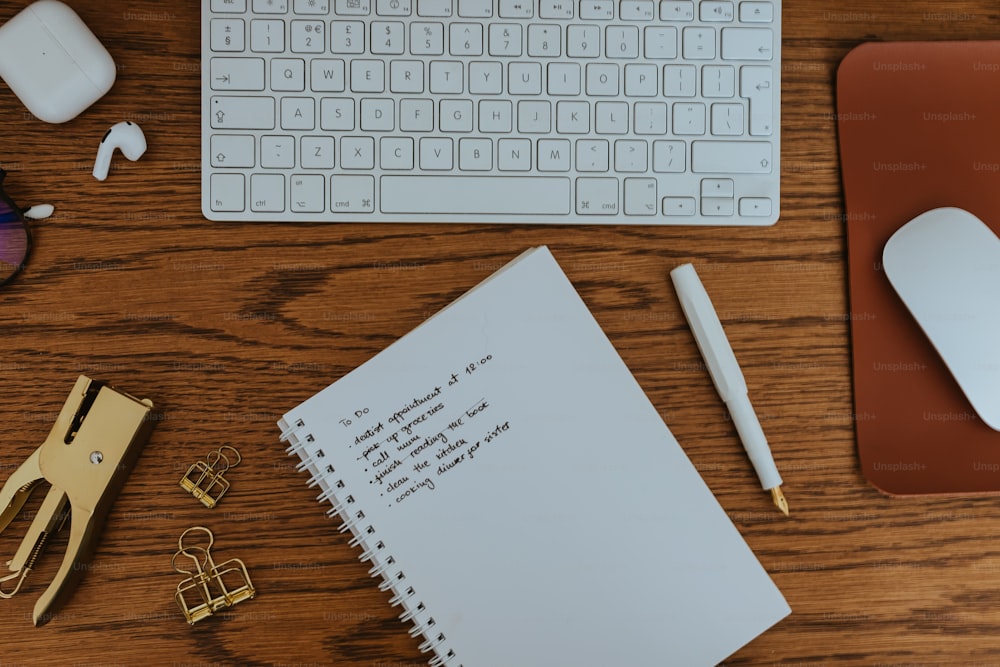 una scrivania con tastiera, mouse e blocco note