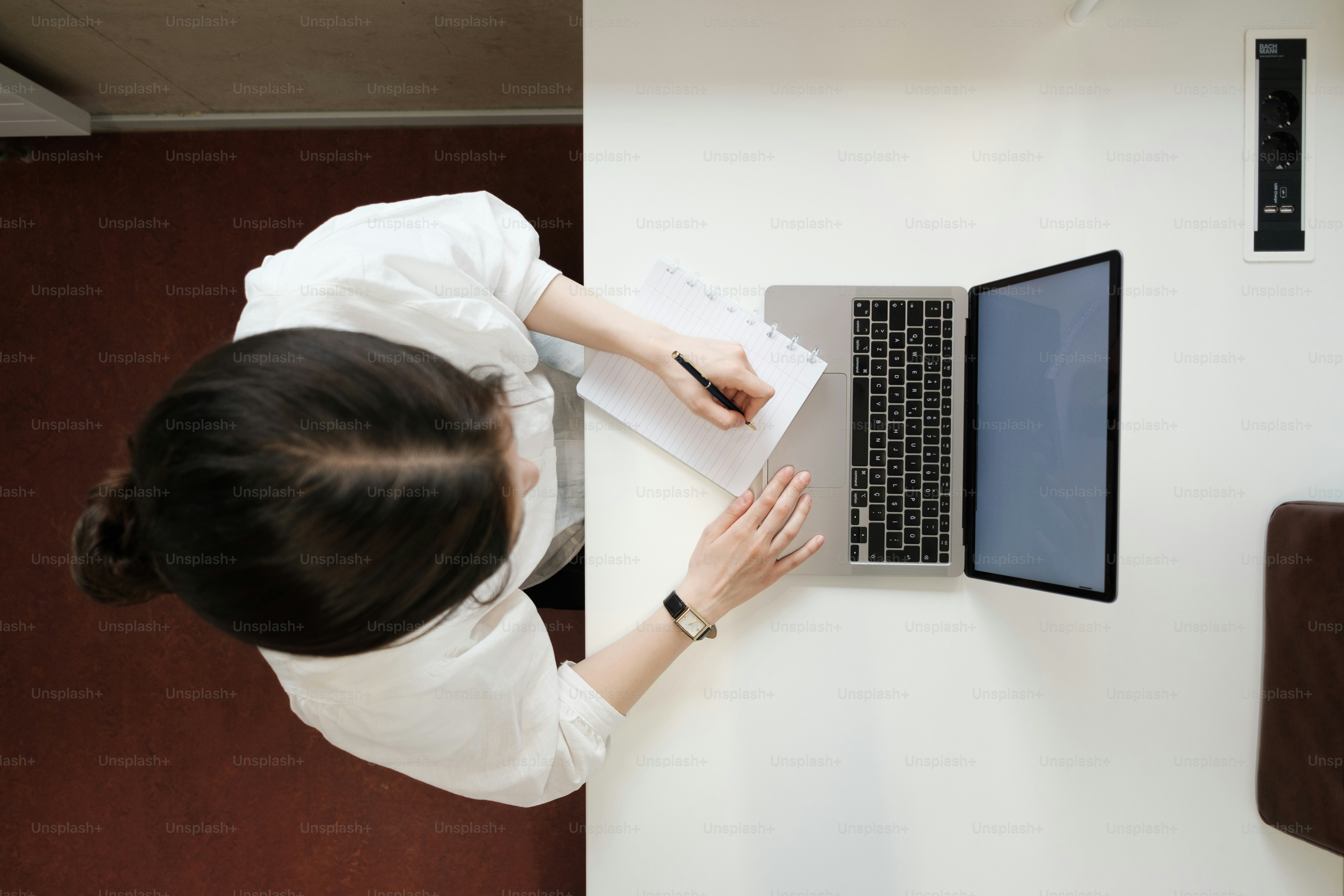 a woman sitting at a desk using a laptop computer