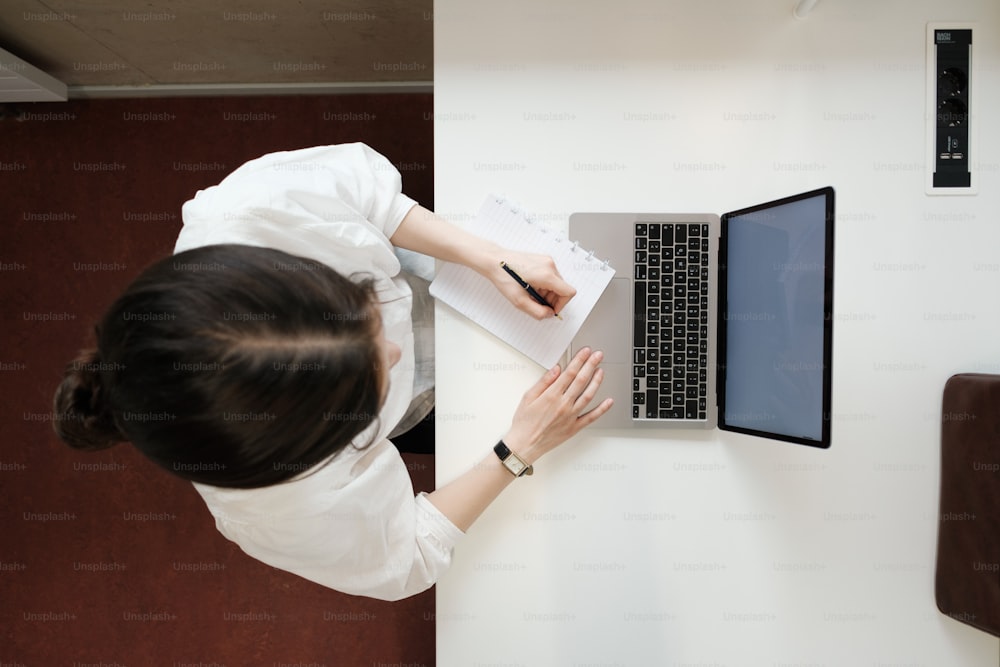 a woman sitting at a desk using a laptop computer