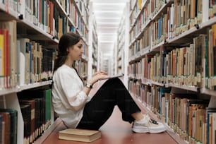 a woman is sitting on the floor in a library