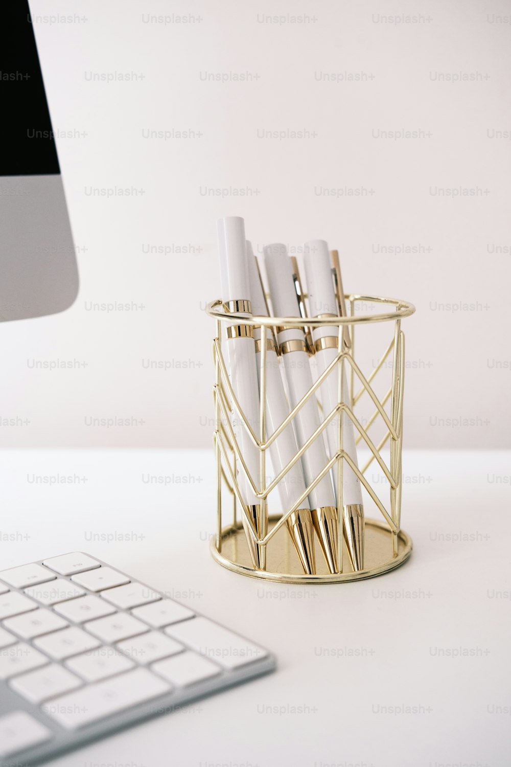 a desk with a keyboard and a pen holder