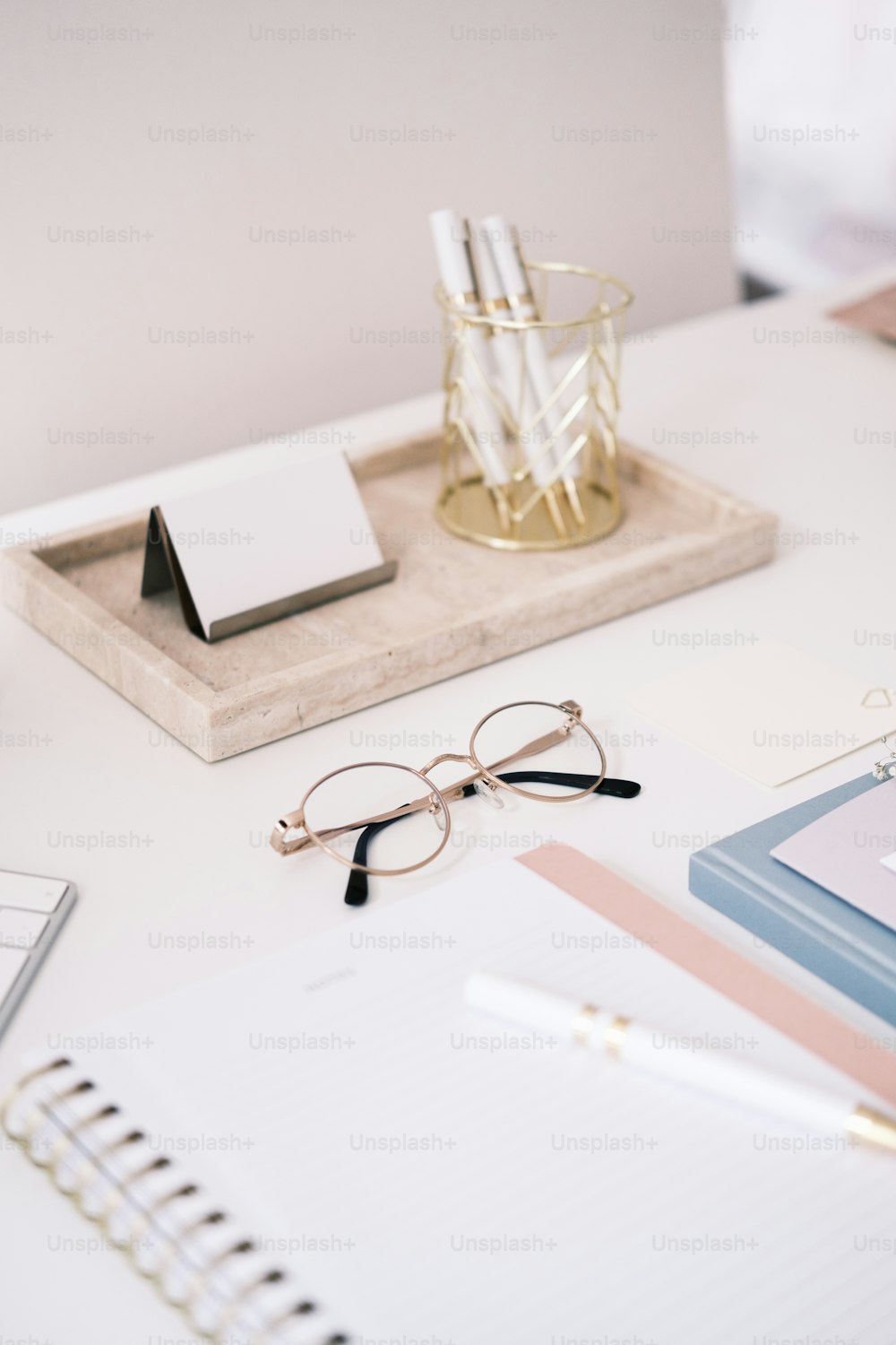 un bureau avec un bloc-notes, un stylo et des lunettes