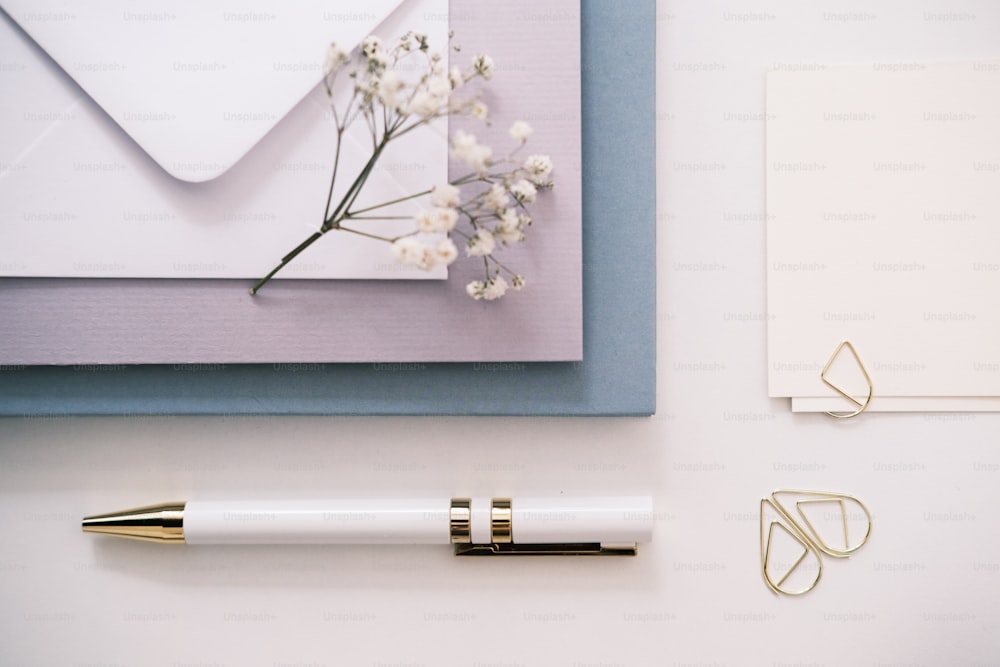 a notepad, a pen, and a flower on a table