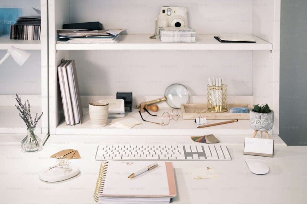 a white desk topped with a keyboard and a monitor