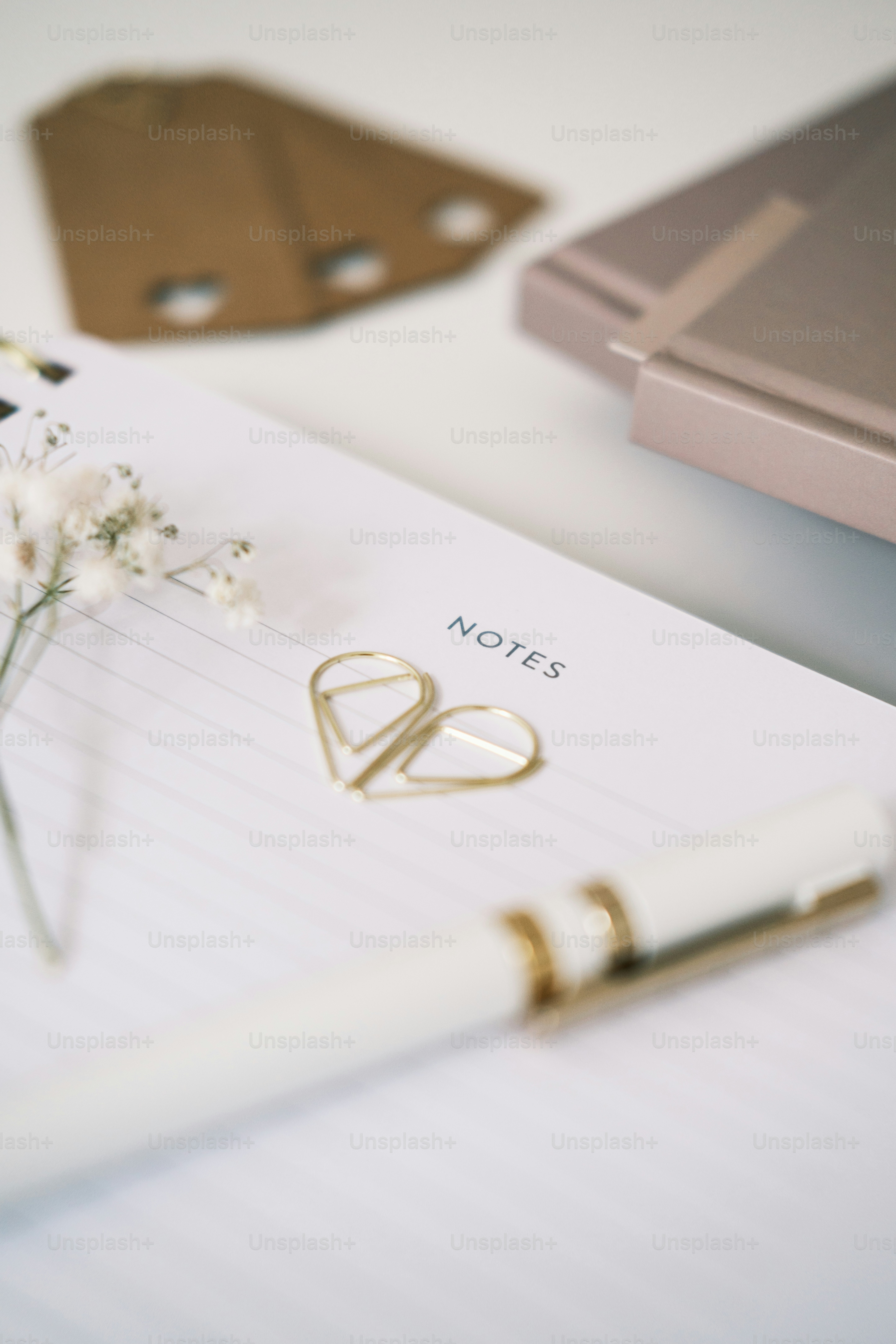 a notepad with a pen and a flower on it