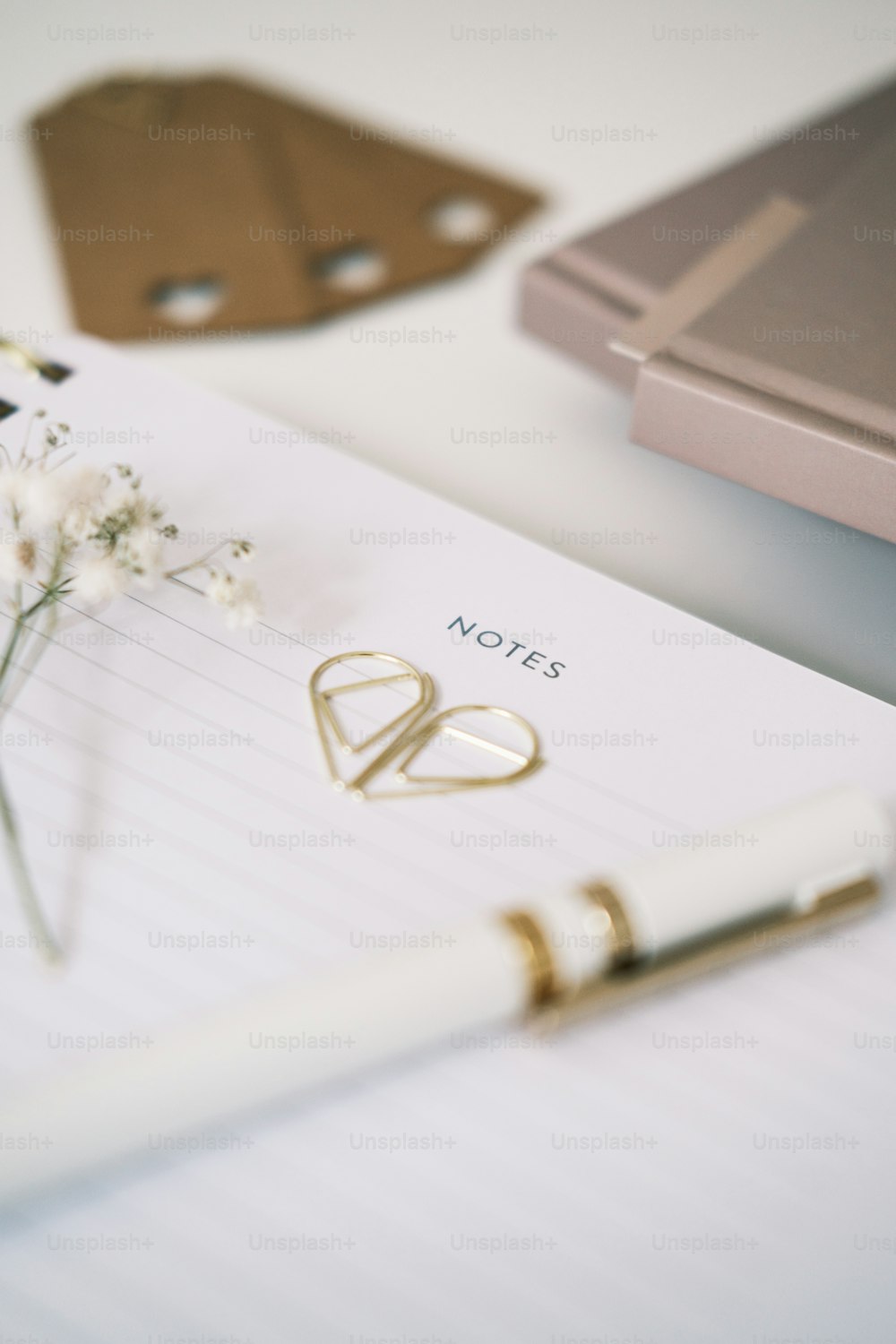 a notepad with a pen and a flower on it