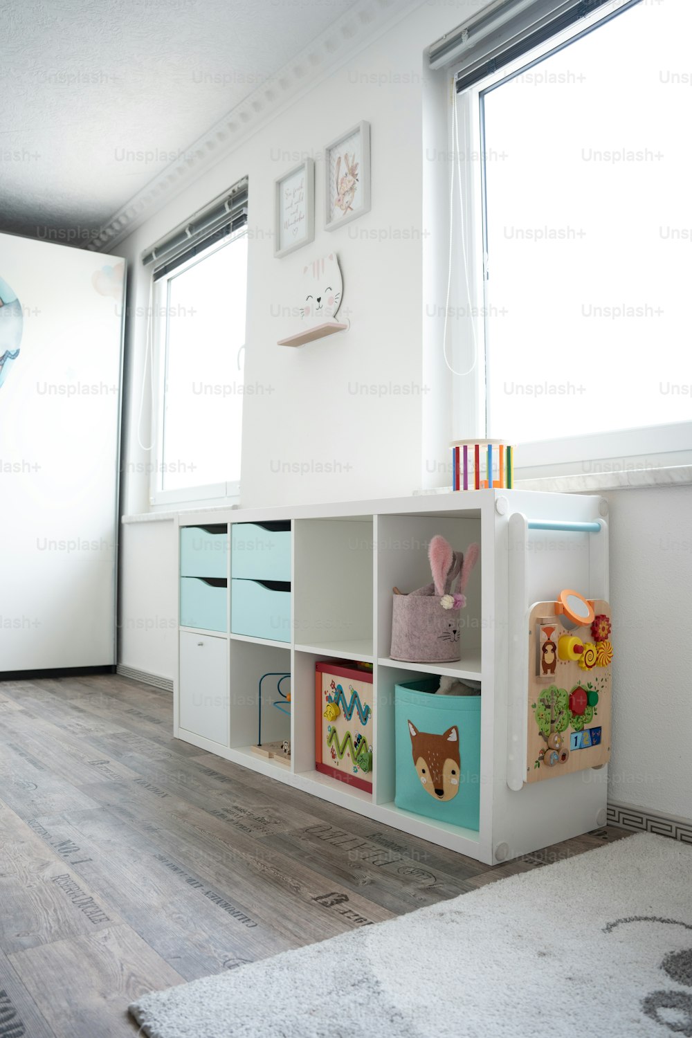 a child's room with a book shelf and toy bins