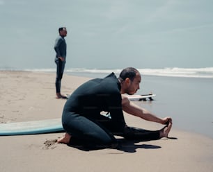Ein Mann, der am Strand neben einem Surfbrett sitzt