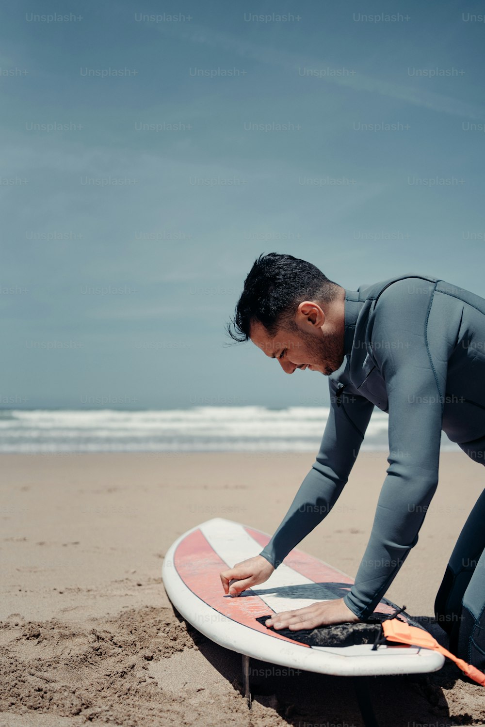 Un homme en combinaison de plongée debout sur une planche de surf
