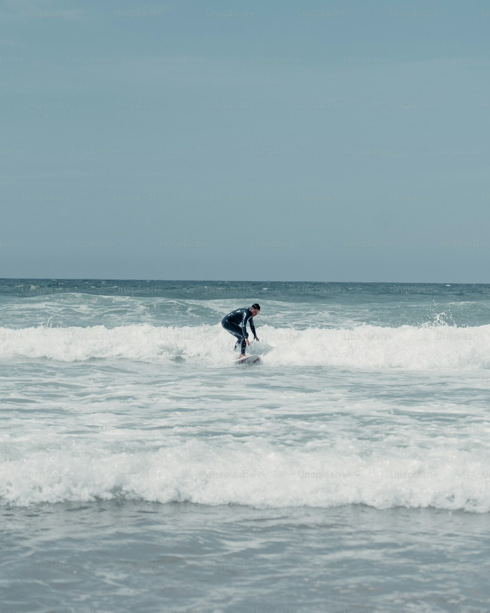 a man riding a wave on top of a surfboard