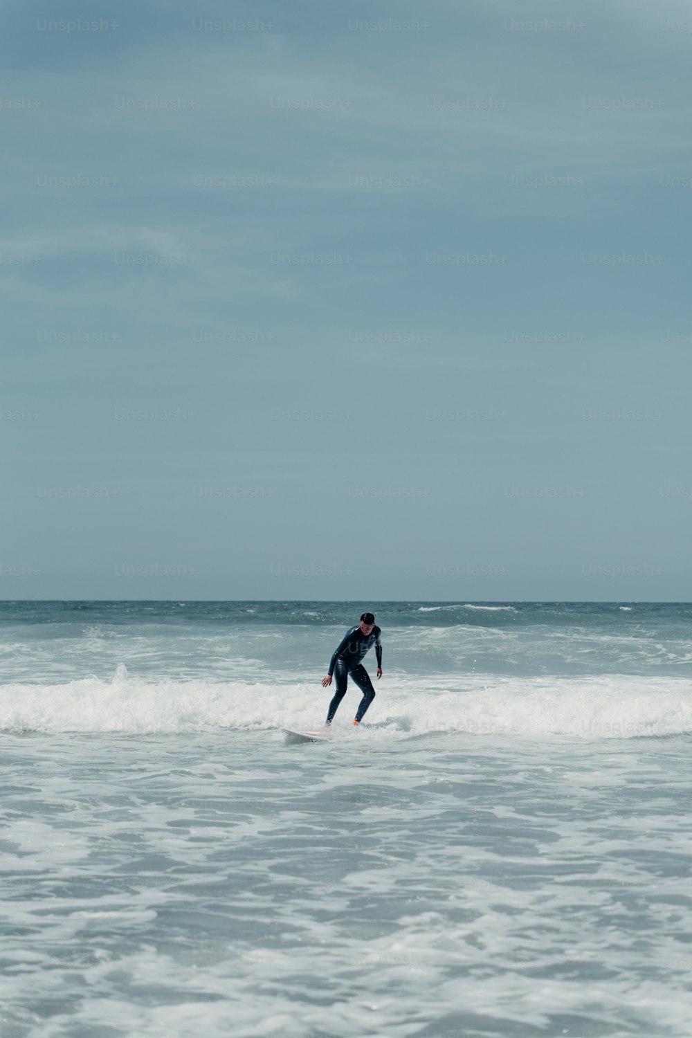 a man riding a wave on top of a surfboard