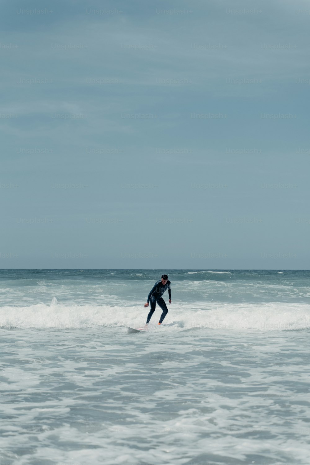 um homem cavalgando uma onda em cima de uma prancha de surf