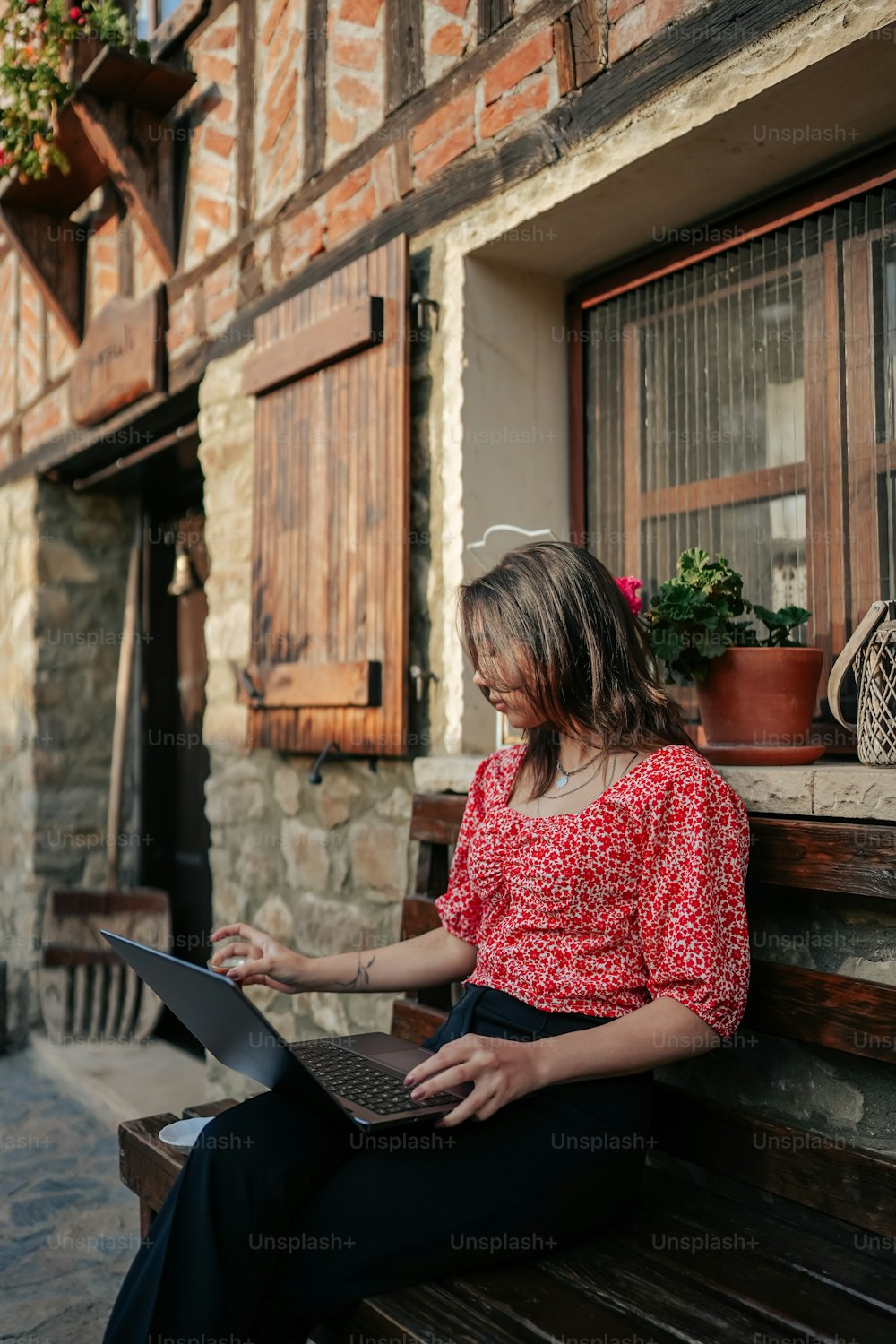 노트북 컴퓨터를 사용하여 벤치에 앉아 있는 여자