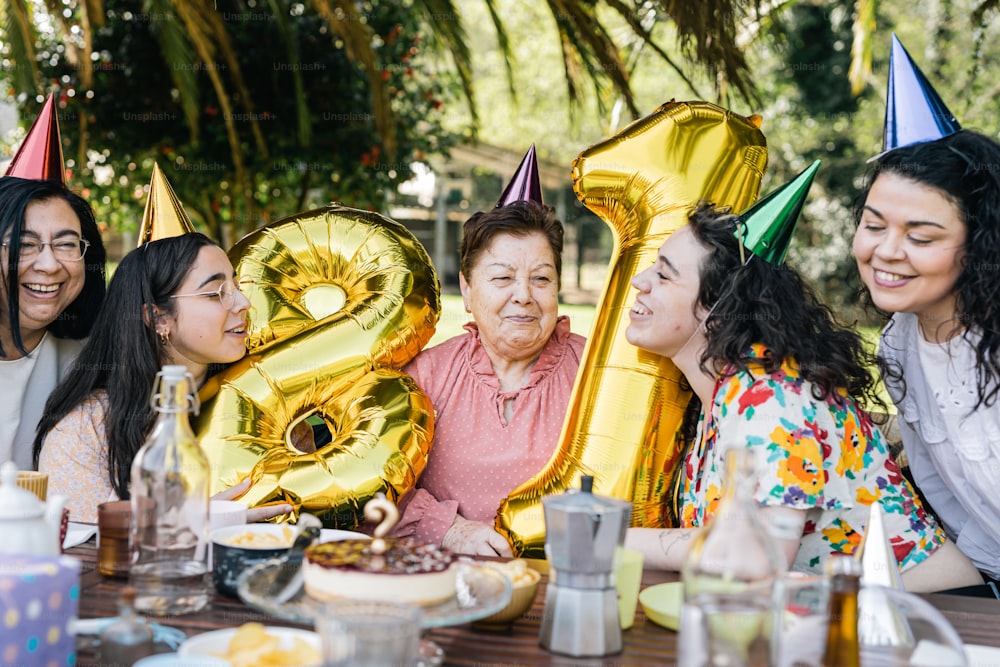 a group of women sitting around a table with balloons