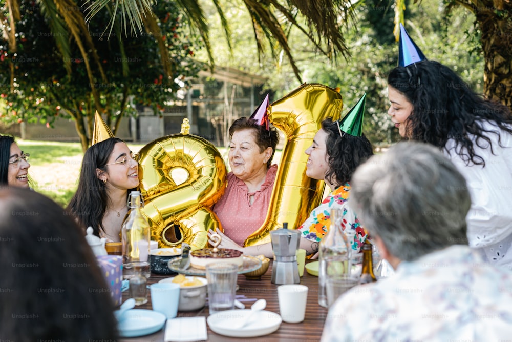 a group of people sitting around a table with balloons
