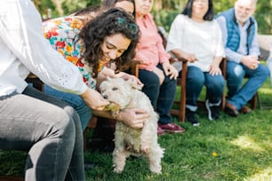a woman is petting a small white dog
