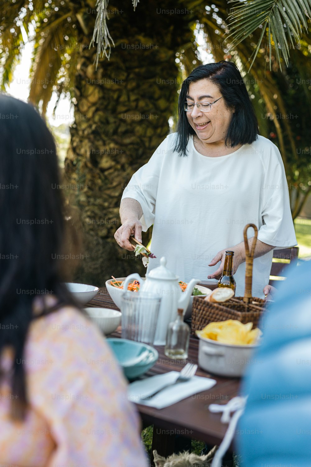 a woman standing next to a table filled with food