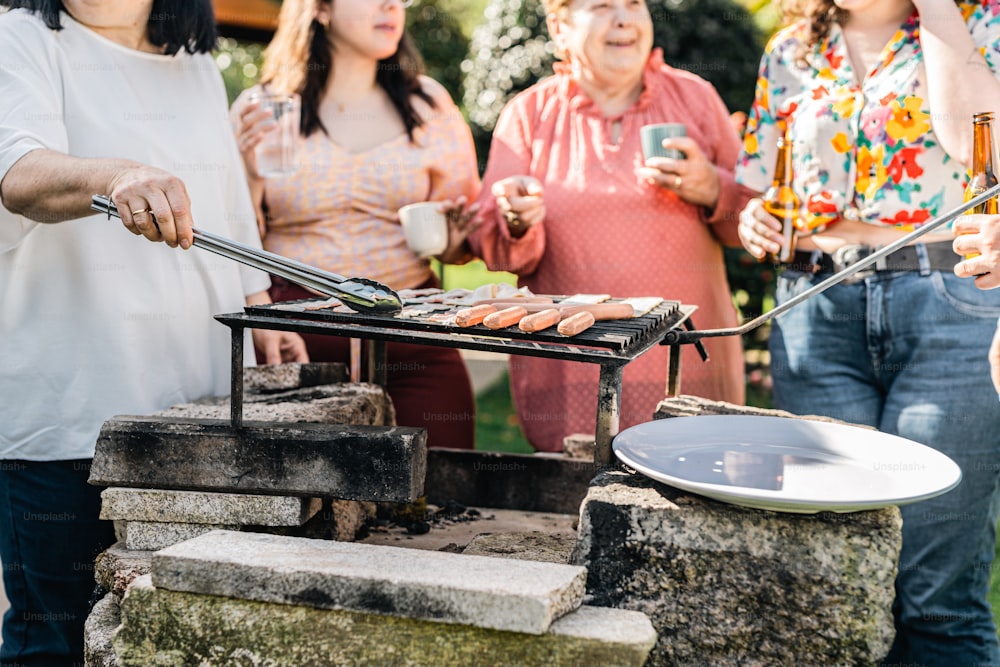 a group of people standing around a grill