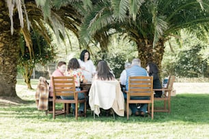 a group of people sitting around a wooden table