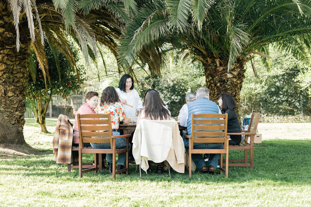 a group of people sitting around a wooden table