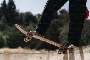 eine Person, die auf einem Skateboard auf einer Zementmauer fährt