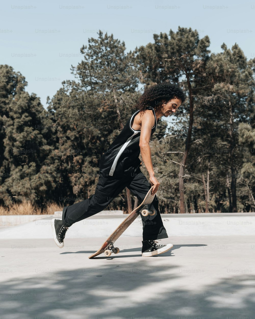 a young man riding a skateboard across a parking lot