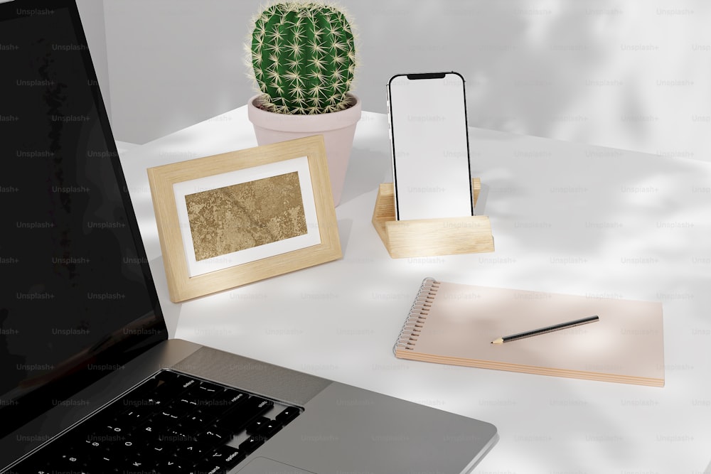 un ordinateur portable posé sur un bureau à côté d’un cactus