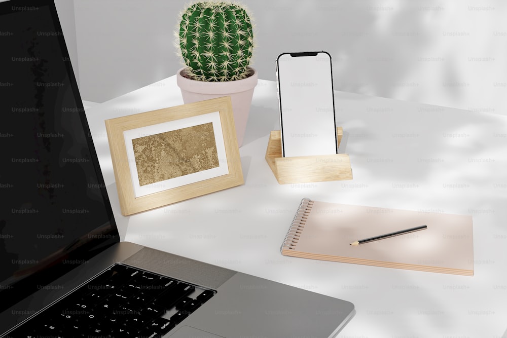 a laptop computer sitting on top of a desk next to a cactus