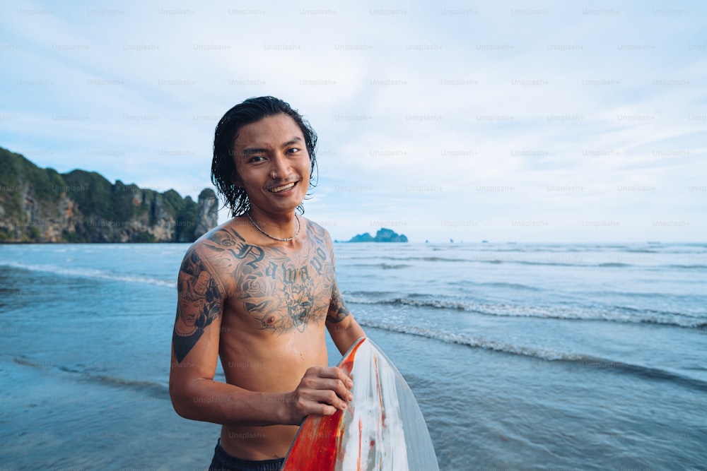 a man holding a surfboard on the beach