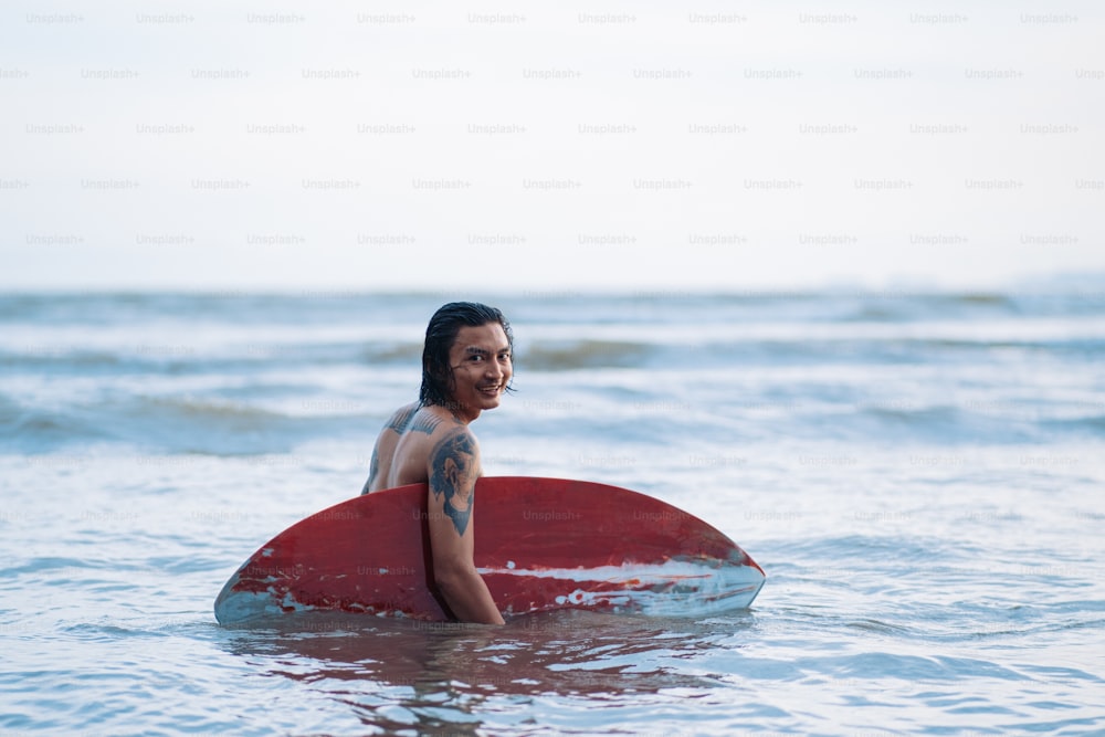 um homem sentado em uma prancha de surf no oceano