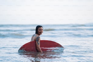 Un homme assis sur une planche de surf dans l’océan