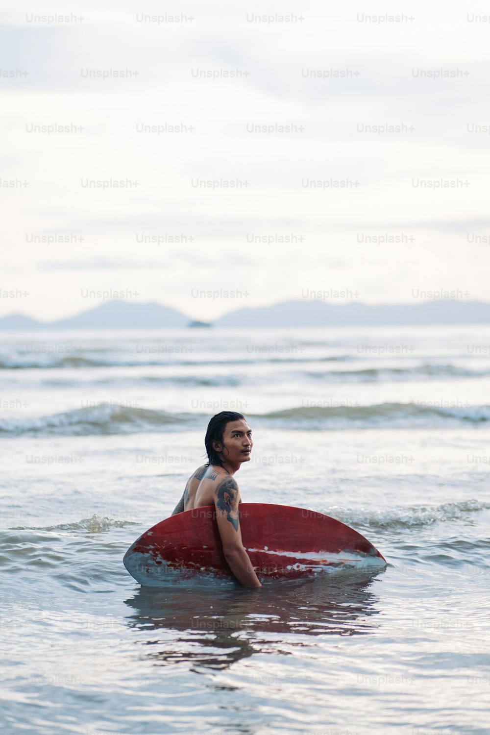 Un uomo seduto su una tavola da surf nell'oceano