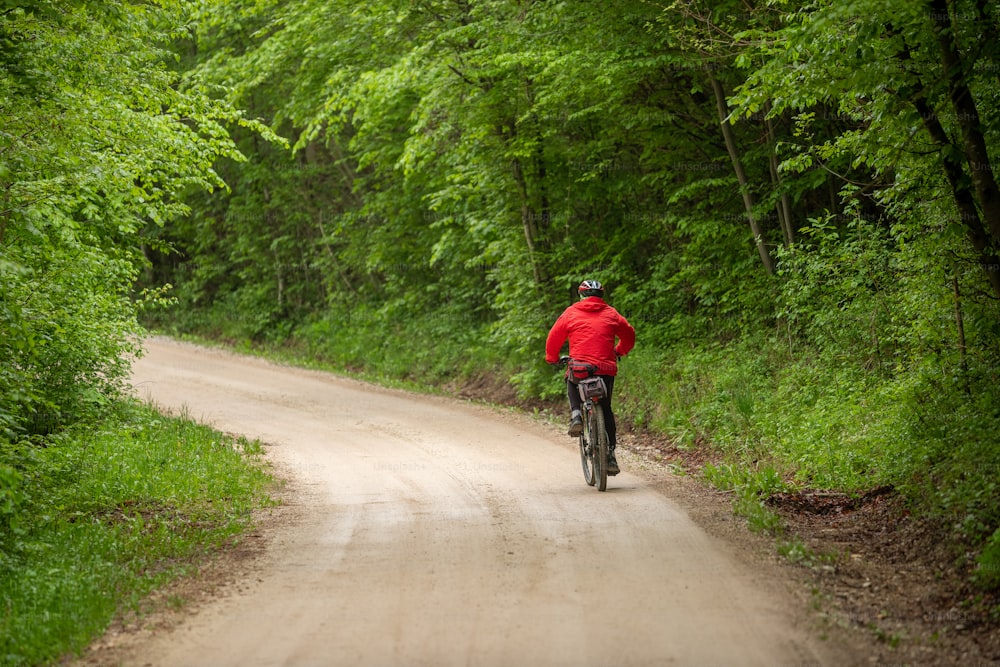 Un hombre montando en bicicleta por un camino de tierra