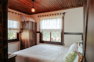 um quarto com uma cama e duas janelas