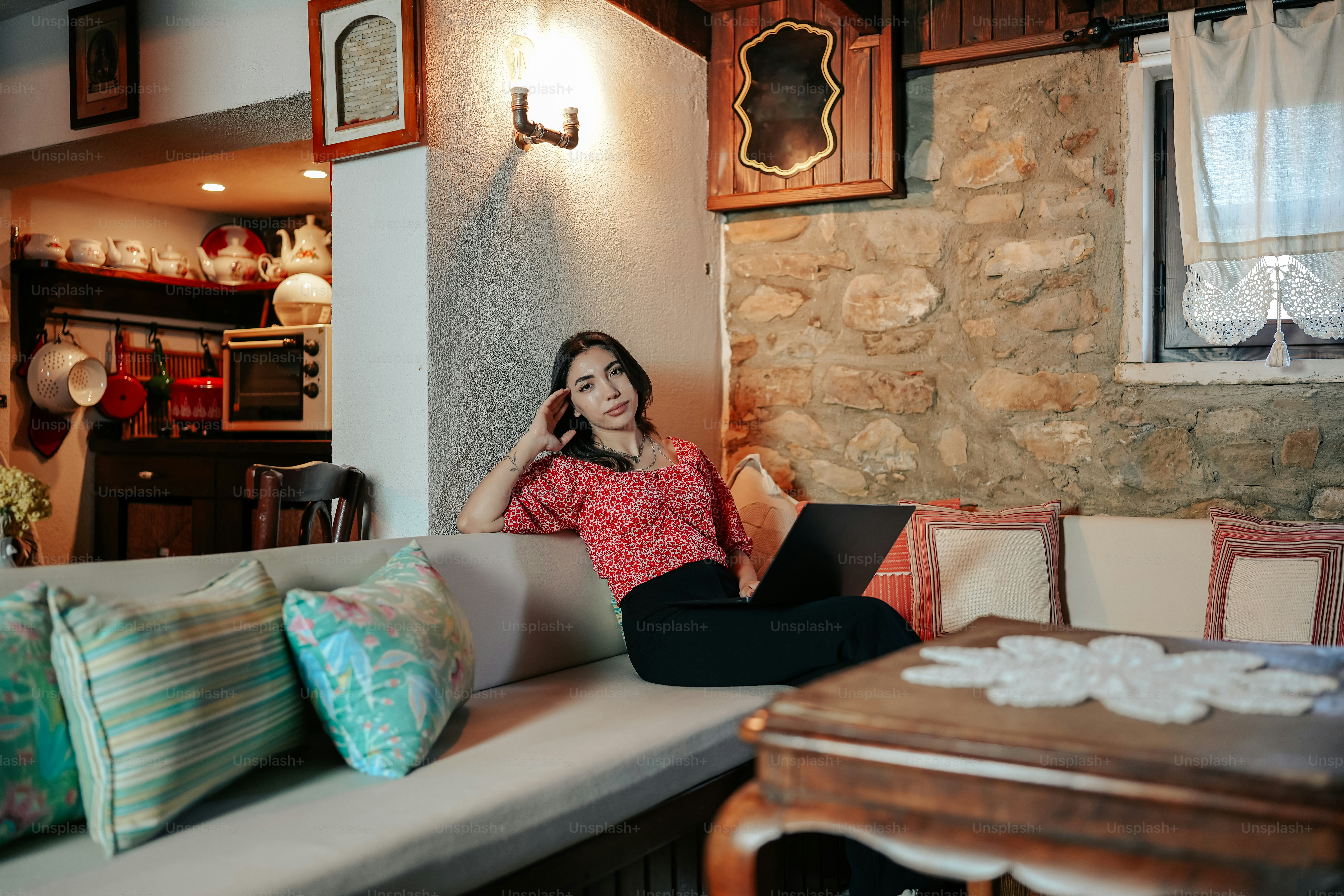 a woman sitting on a couch using a laptop computer