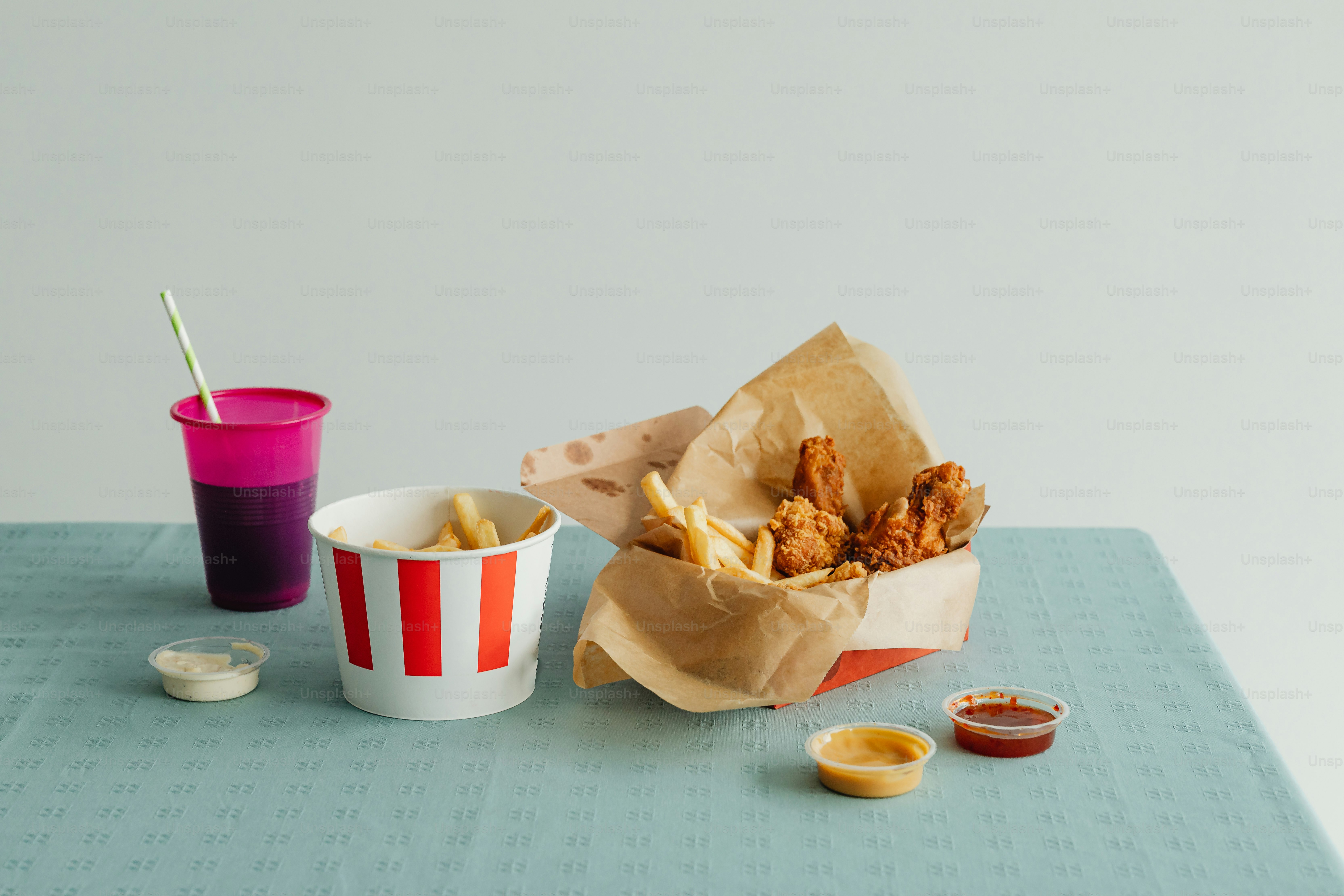a table topped with a basket of food next to a cup of drink