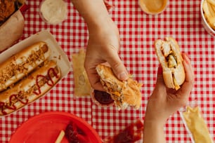 a person holding a hot dog in their hand