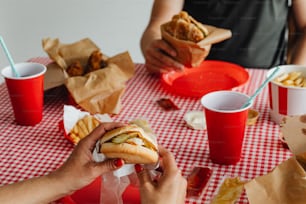 una persona che mangia un hot dog a un tavolo da picnic