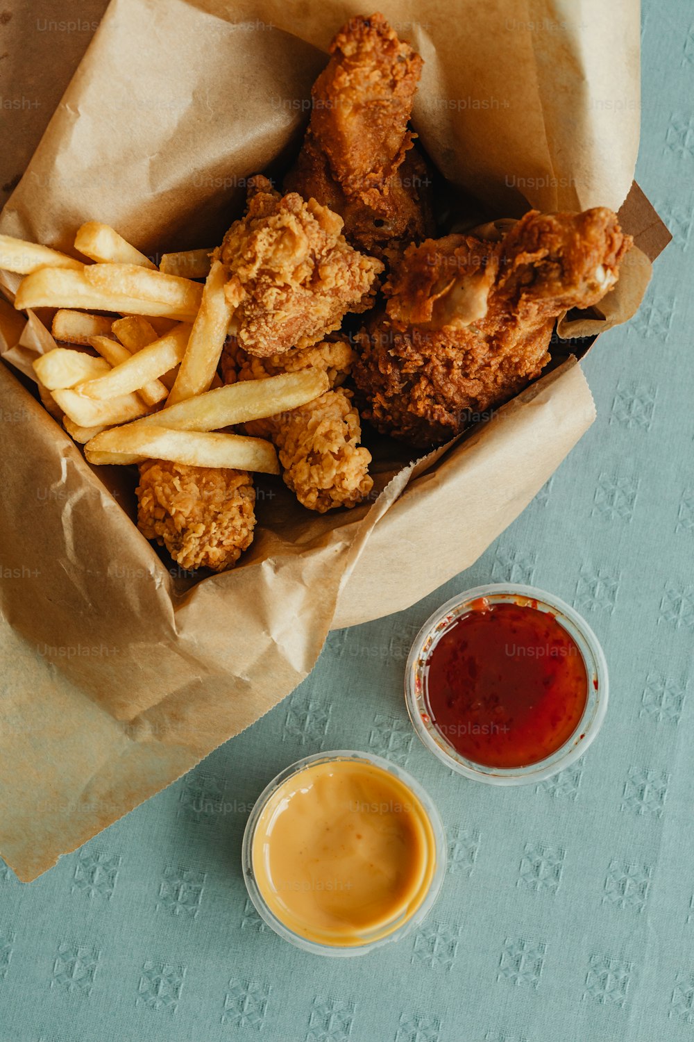 a basket filled with fried chicken and fries next to ketchup