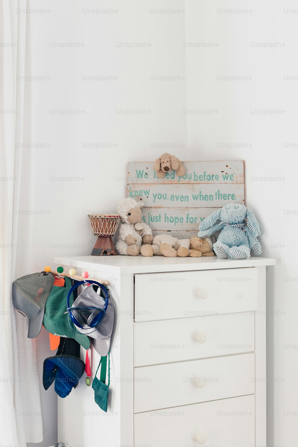 a chest of drawers with a teddy bear on top of it